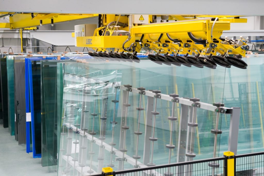 Robotic suction-cup handler moving large glass panes in the Drutex glass plant